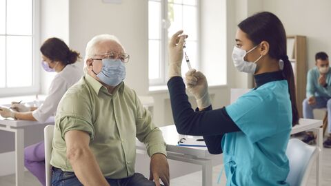 Älterer Mann erhält Impfung