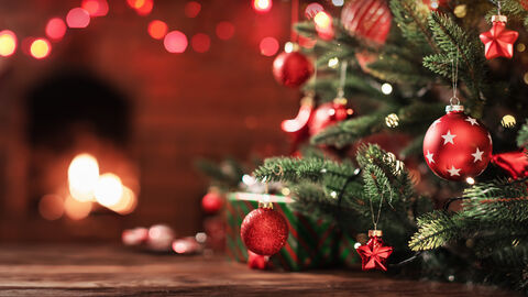 Ein geschmückter Weihnachtsbaum vor einem Kamin