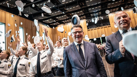 Ministerpräsident Boris Rhein und Innenminister Roman Poseck stehen in einer Menschenmenge.