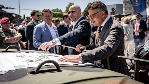 Ministerpräsident Boris Rhein schaut auf eine Karte, die auf einer Motorhaube liegt. 