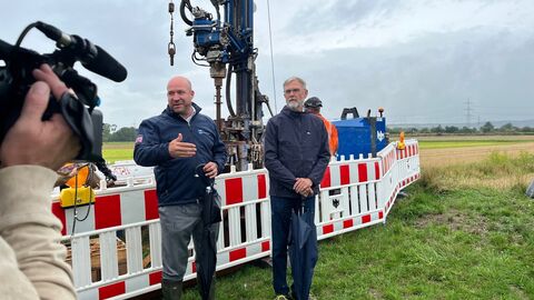 Zwei Männer stehen vor Kamera. Im Hintergrund sieht man einen abgesperrten Bereich