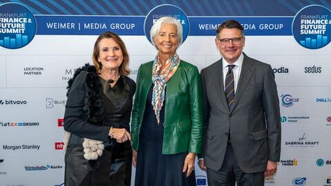 Ministerpräsident Rhein steht mit zwei Personen zusammen vor einem Aufsteller des Finance & Future Summit 